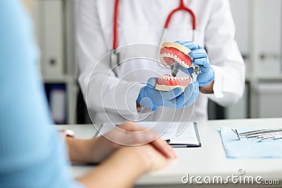 Dentist in dental clinic shows beautiful jaw with straight teeth to client Stock Photo