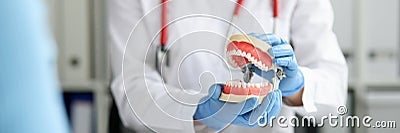 Dentist in dental clinic shows beautiful jaw with straight teeth to client Stock Photo