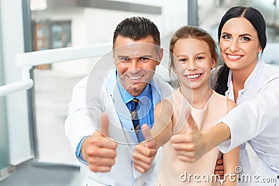 Dentist doctor, assistant and little girl all smiling at camera Stock Photo