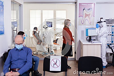 Dentist doctor in ppe suit consulting patient in dental clinic Stock Photo