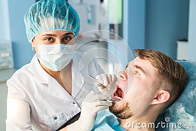 Dentist doing a dental treatment on a patient close-up Stock Photo