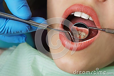 Dentist examines teeth of girl Stock Photo