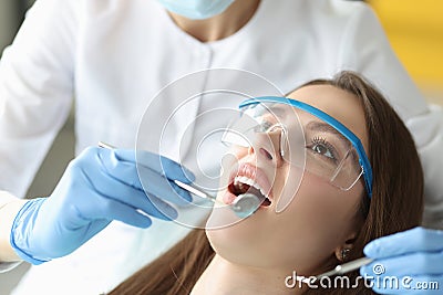 Dentist examines woman oral cavity in office closeup Stock Photo