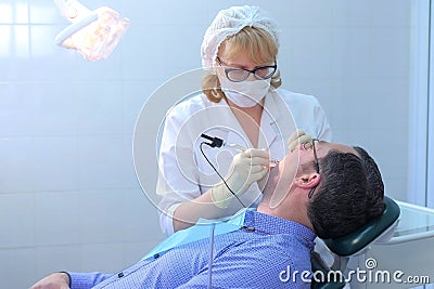 Dentist examining patient gums with probe using method of computer diagnostics. Stock Photo