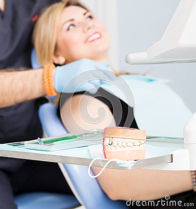 Dentist explaing dental treatment with denture to female patient Stock Photo