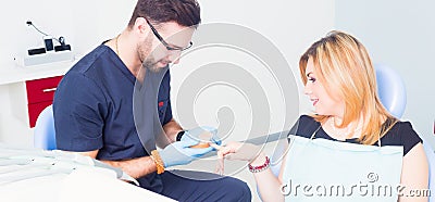 Dentist explaing dental treatment with denture to female patient Stock Photo