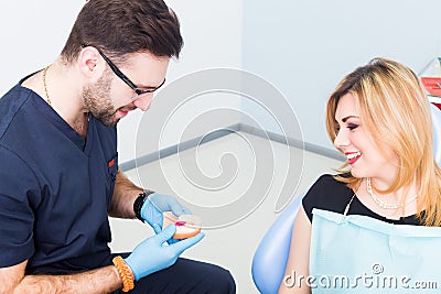 Dentist explaing dental treatment with denture to female patient Stock Photo