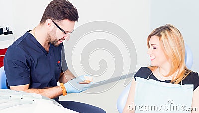 Dentist explaing dental treatment with denture to female patient Stock Photo