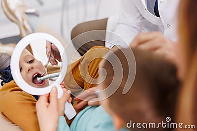 Dentist fixing tooth to a little boy Stock Photo
