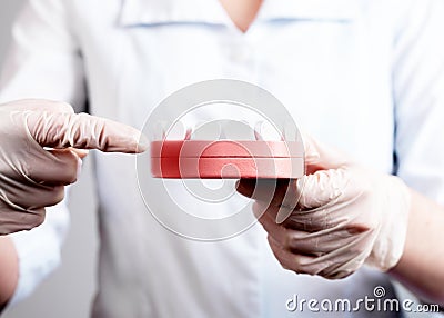 Dentist forefinger pointing to gingiva inflammation at jaw model with teeth and red point. Periodontal diseases Stock Photo