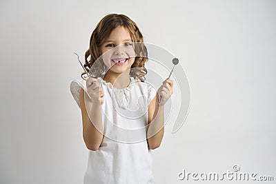 Dentist girl holding dental tools on white background Stock Photo