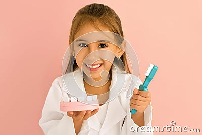 Dentist girl holds a model of a human jaw and a toothbrush in her hands Stock Photo