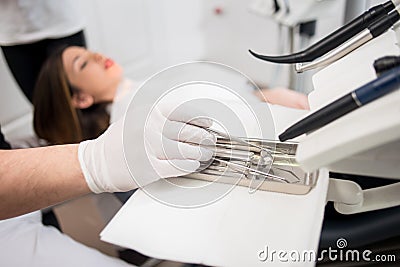 Dentist with gloved hands is treating patient with dental tools in dental clinic. Dentistry Stock Photo