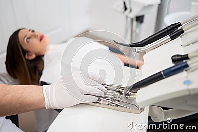 Dentist with gloved hands is treating patient with dental tools in dental hospital. Dentistry Stock Photo