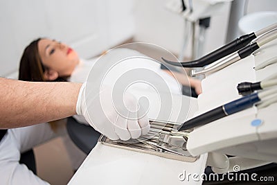 Dentist with gloved hands is treating patient with dental tools in dental office. Dentistry Stock Photo