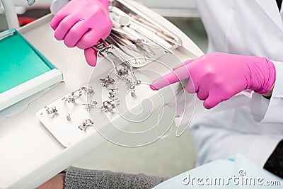 Dentist with gloved hands is working with dental equipment in dental office. Dentistry Stock Photo