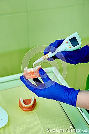 Dentist holding teeth model denture, showing with diagnostic periodontal probe Stock Photo