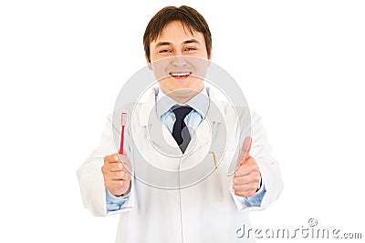 Dentist holding toothbrush and showing thumbs up Stock Photo