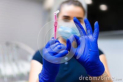Dentist holds brush for cleaning the interdental spaces and shows ok gesture. Stock Photo
