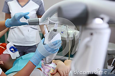 The dentist holds a lamp to whiten the tooth enamel.An unrecognizable person.Teeth whitening with cold light.Cosmetic Stock Photo