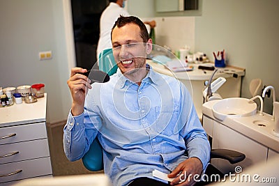 Dentist Inspecting Teeth Of Young Man. Stock Photo