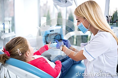 Dentist and little girl looking at x-ray of teeth Stock Photo