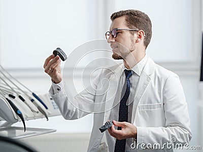 Dentist looking at photopolymer jaw printed on a 3d printer. Stock Photo