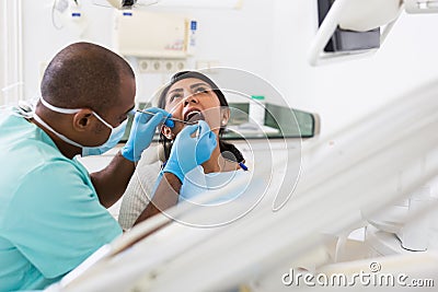 Dentist male in uniform is examinating of female in clinic Stock Photo