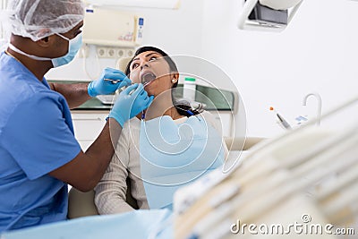 Dentist male in uniform is examinating of female in clinic Stock Photo