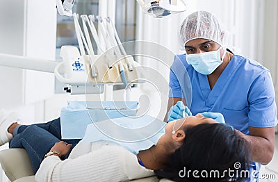 Dentist male in uniform is examinating of female in clinic Stock Photo