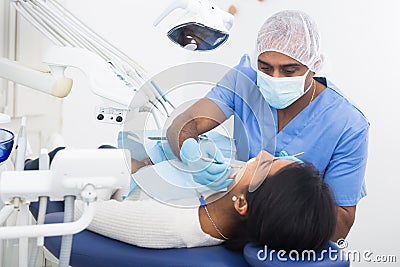 Dentist male in uniform is examinating of female in clinic Stock Photo