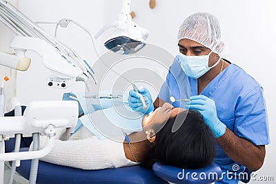 Dentist male in uniform is examinating of female in clinic Stock Photo