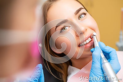 Dentist performing teeth grinding procedures in clinic Stock Photo