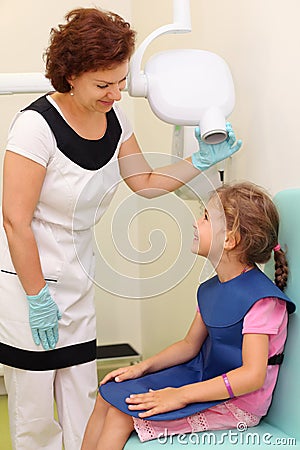 Dentist prepares girl to jaw x-ray image Stock Photo