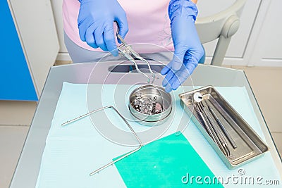 A dentist prepares a latex scarf with metal clips Stock Photo
