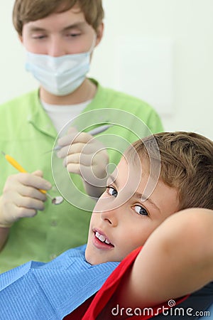 Dentist prepares to treat teeth of boy Stock Photo