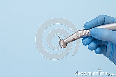 Dentist`s hand in glove with dental handpiece Stock Photo