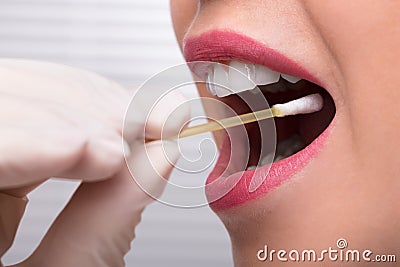 Dentist`s Hand Taking Saliva Test From Woman`s Mouth Stock Photo