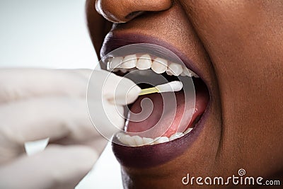 Dentist`s Hand Taking Saliva Test From Woman`s Mouth Stock Photo