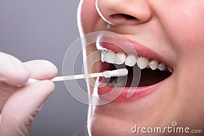 Dentist`s Hand Taking Saliva Test From Woman`s Mouth Stock Photo