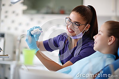 Dentist show to his female patient teeth model in jaw Stock Photo