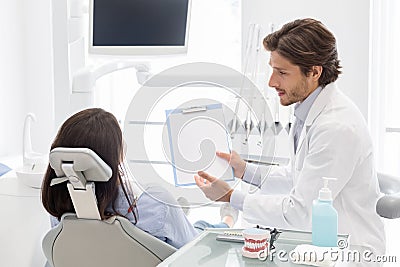Dentist showing patient blank empty paper to fill up survey Stock Photo