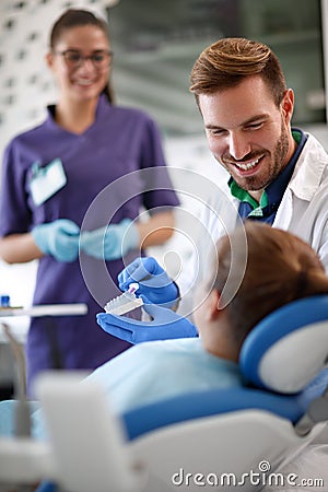 Dentist shows properly brushing teeth model of teeth in jaw Stock Photo