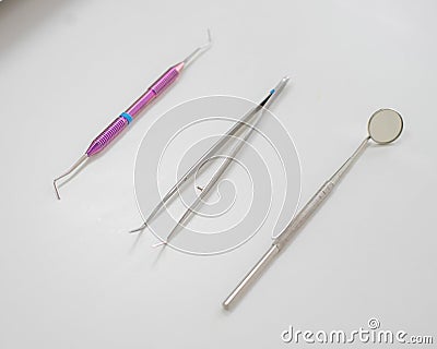 Dentist table with tools on a white background top view. A mirror, tweezers and a probe are on the doctors table. Oral Stock Photo