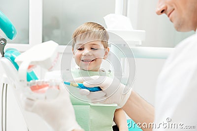 Dentist teaching little boy how to cleaning teeth Stock Photo