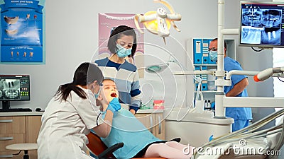 Dentist technician with gloves explaining the process to kid patient Stock Photo