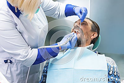 Dentist with tool cleaning teeth. Stock Photo