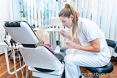 Dentist treating a child in her office Stock Photo