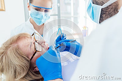 Dentist during treatment of a senior patient Stock Photo