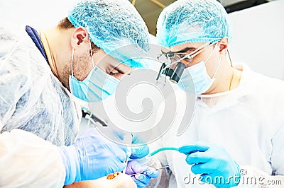 Dentist in uniform perform operation at dentistry office Stock Photo